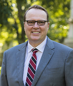 Headshot of Julius Fridriksson in a suit and tie outdoors.