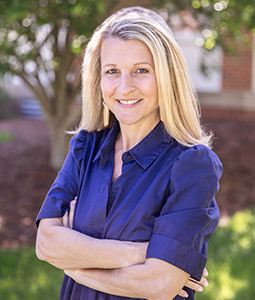 Headshot of Stephanie McLawhorn in a blue dress outdoors.