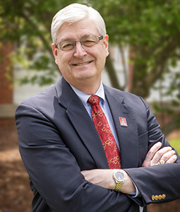 Headshot of Rob McMahon outside wearing a suit and tie.
