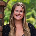 Ryanne is picture from the shoulders up. She has blonde hair, fair skin and is smiling.