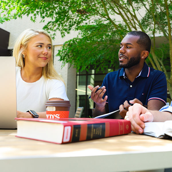 Students working at a table in the courtyard.