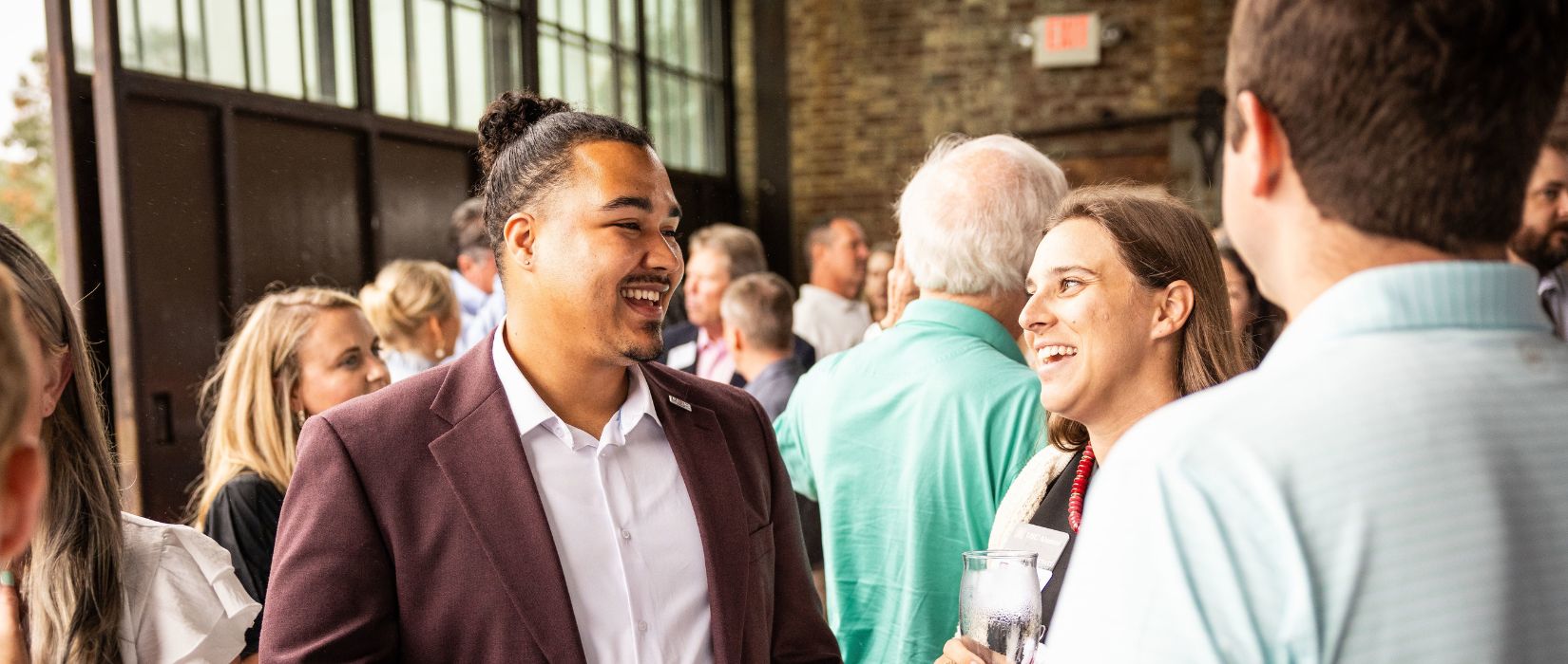 Alumni laughing at an alumni happy hour event