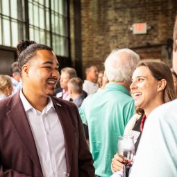 Alumni laughing at alumni happy hour event