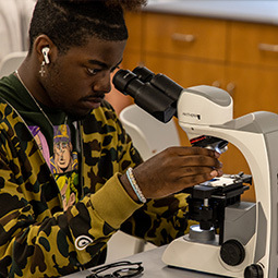 student with microscope