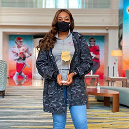 Alexandria Hill Alexandria Hill stands holding a trophy in the NFL Club
